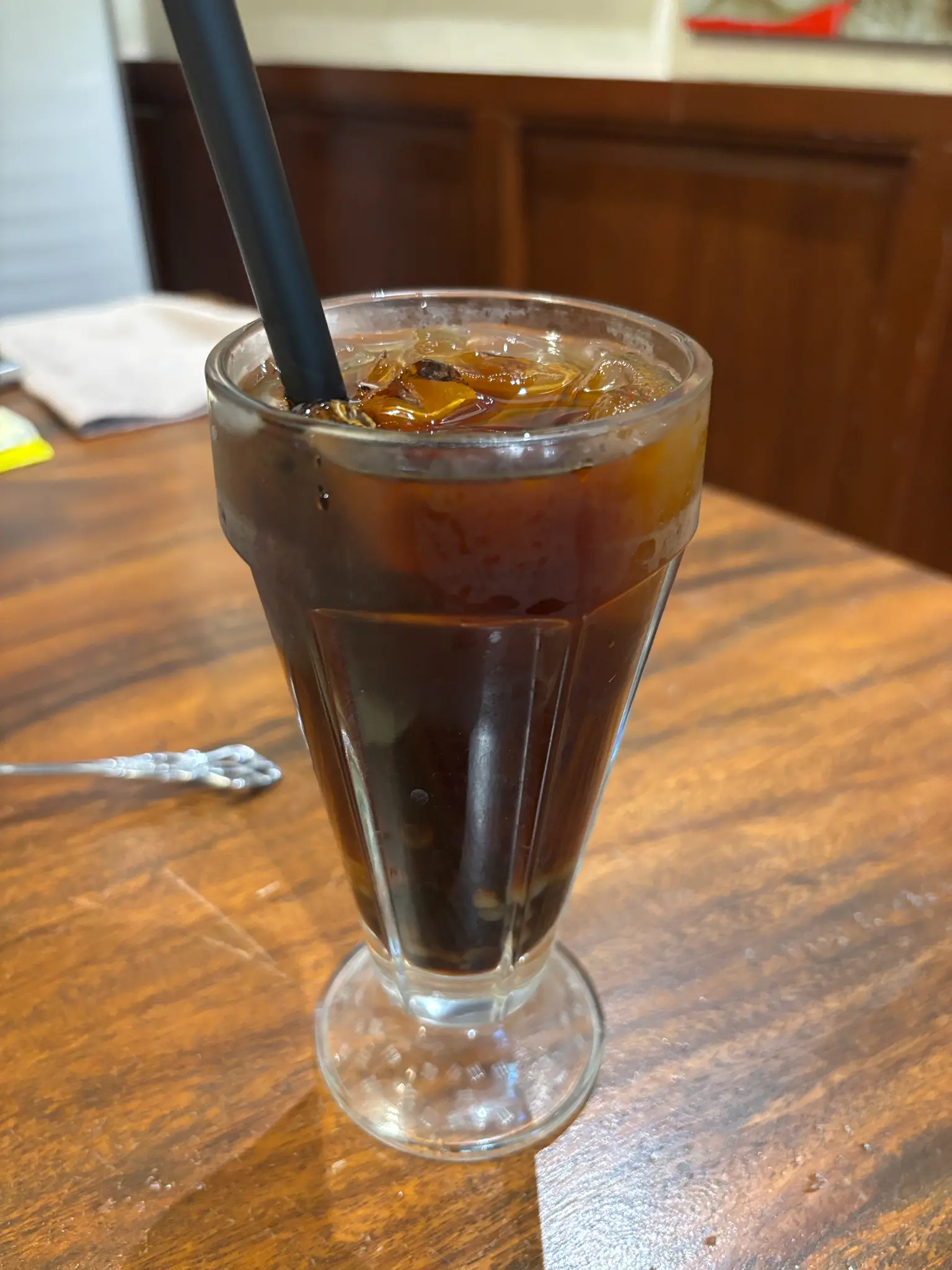A chilled dark coffee provides a bold, refreshing accompaniment to the meal.